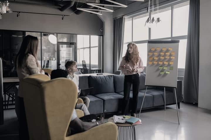 A team discussing a process at a whiteboard with sticky notes.